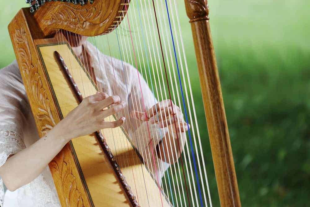 A golden paraguayan harp is being played outdoors.