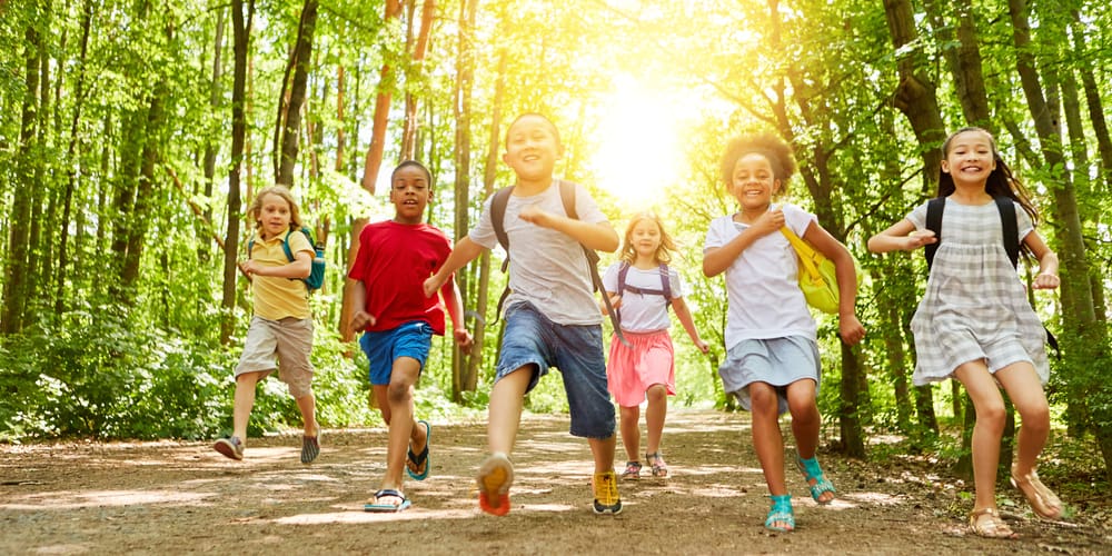 Kids running in the woods.