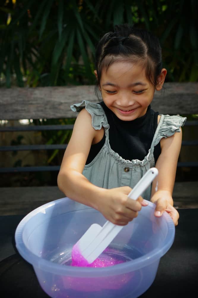Girl making slime in a basin.
