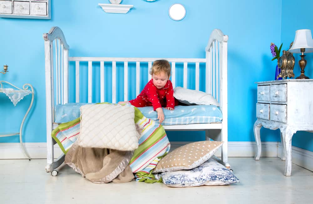Toddler playing on his bed.