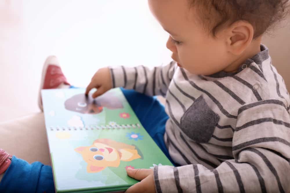 17 Gifts for Kids Who Love to Read 3 This is a kid playing with a picture book.