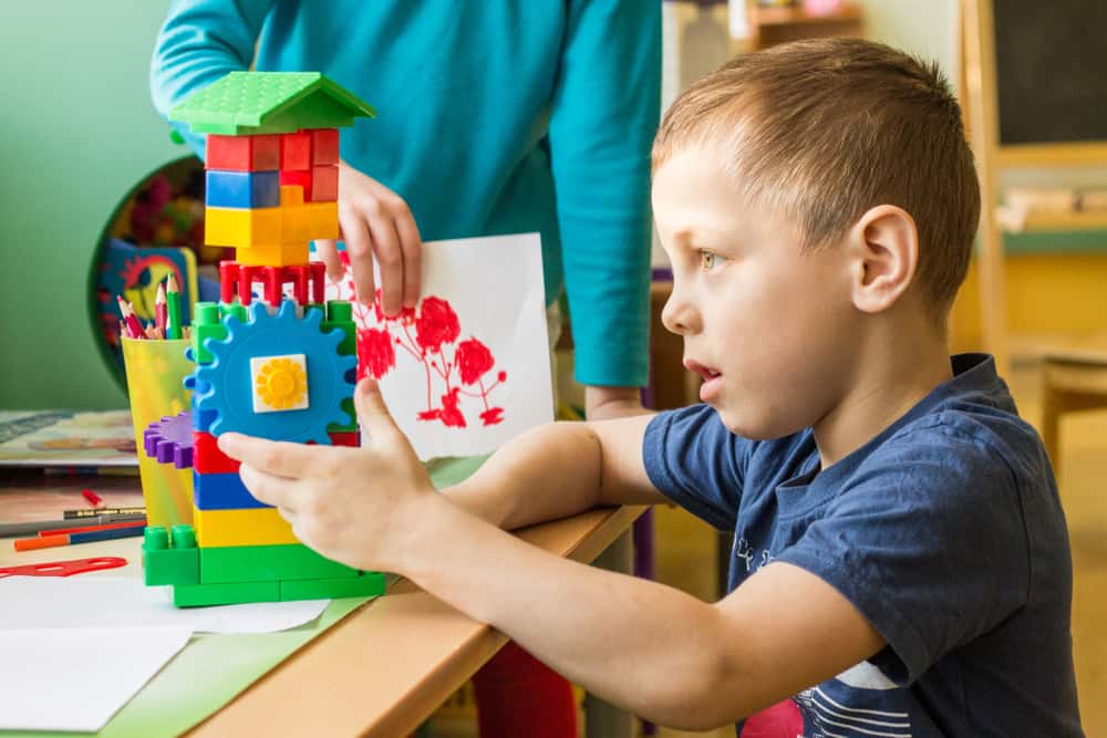 A young boy playing with colorful building blocks.