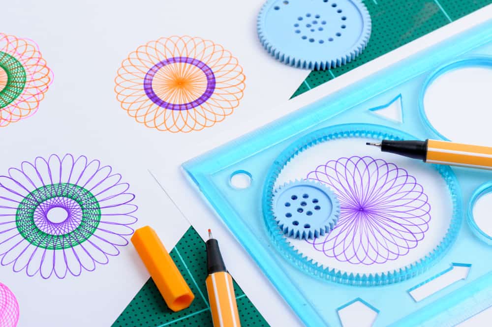 A close look at a Spirograph kit with a few patterns done.