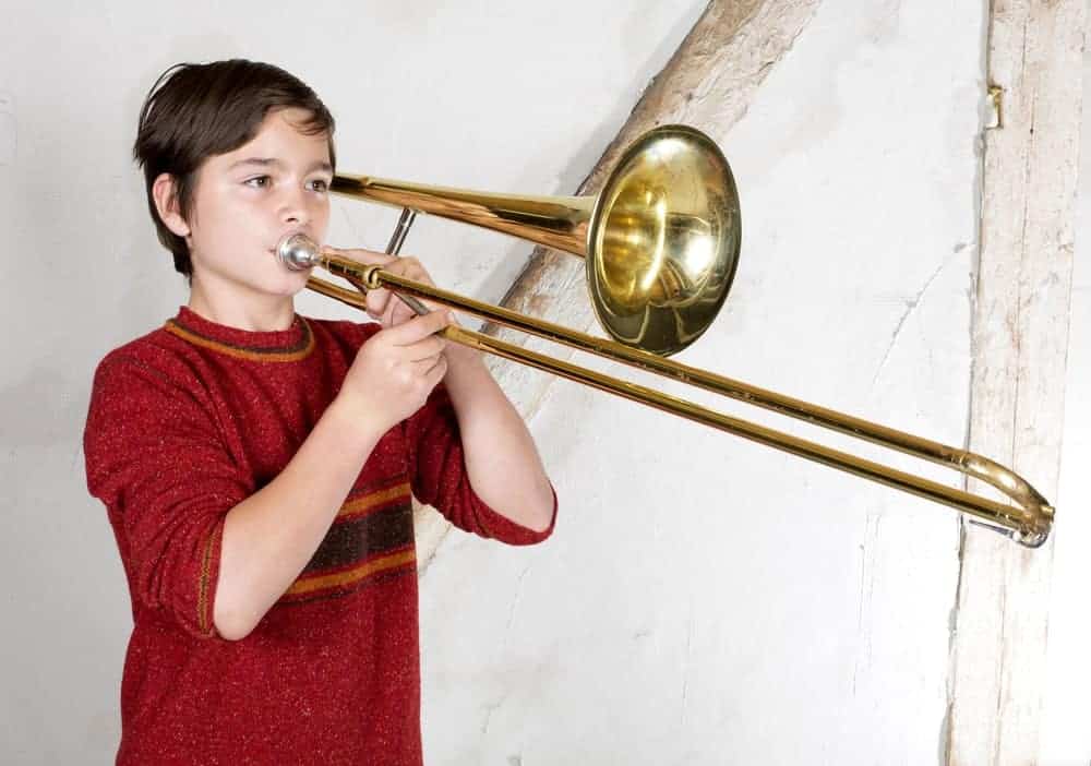 A boy plays the trombone.