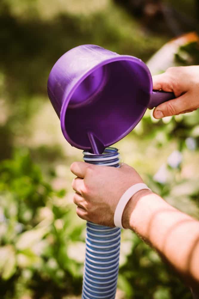 This is a close look at someone pouring water into a tube.