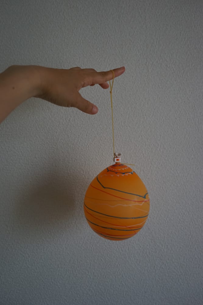 This is a close look at a kid playing with a water balloon yoyo.