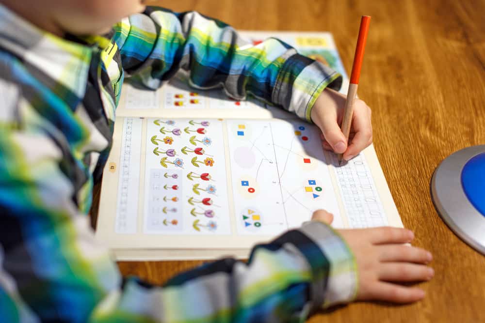22 Best Drawing Toys for Kids Who Like to Draw 10 Little boy doing homework.