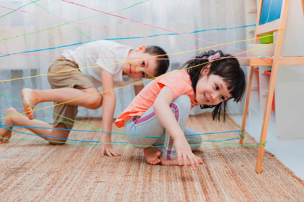 A couple of kids playing indoor obstacle course.