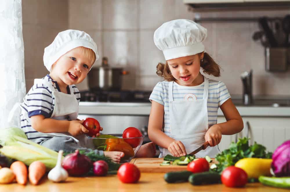 7 Best Cooking Toys for Kids Who Like to Cook 1 Children preparing vegetables in the kitchen.