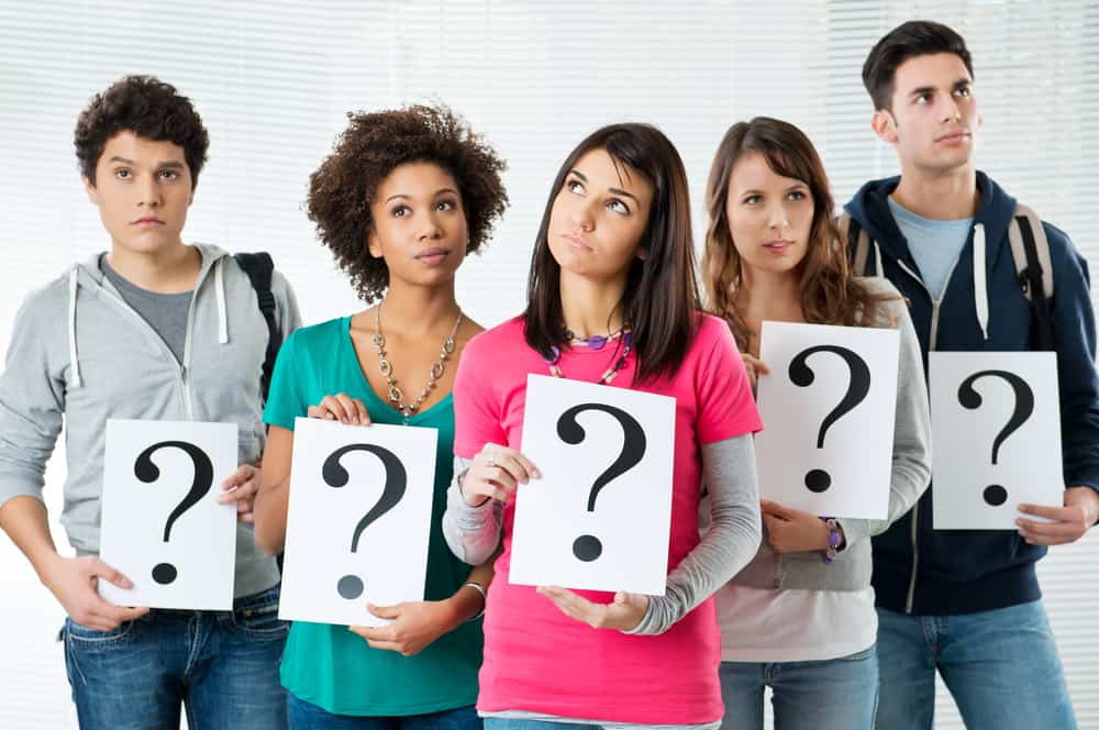 250 Best Would You Rather Questions for Teens 1 Various teenagers holding question marks.