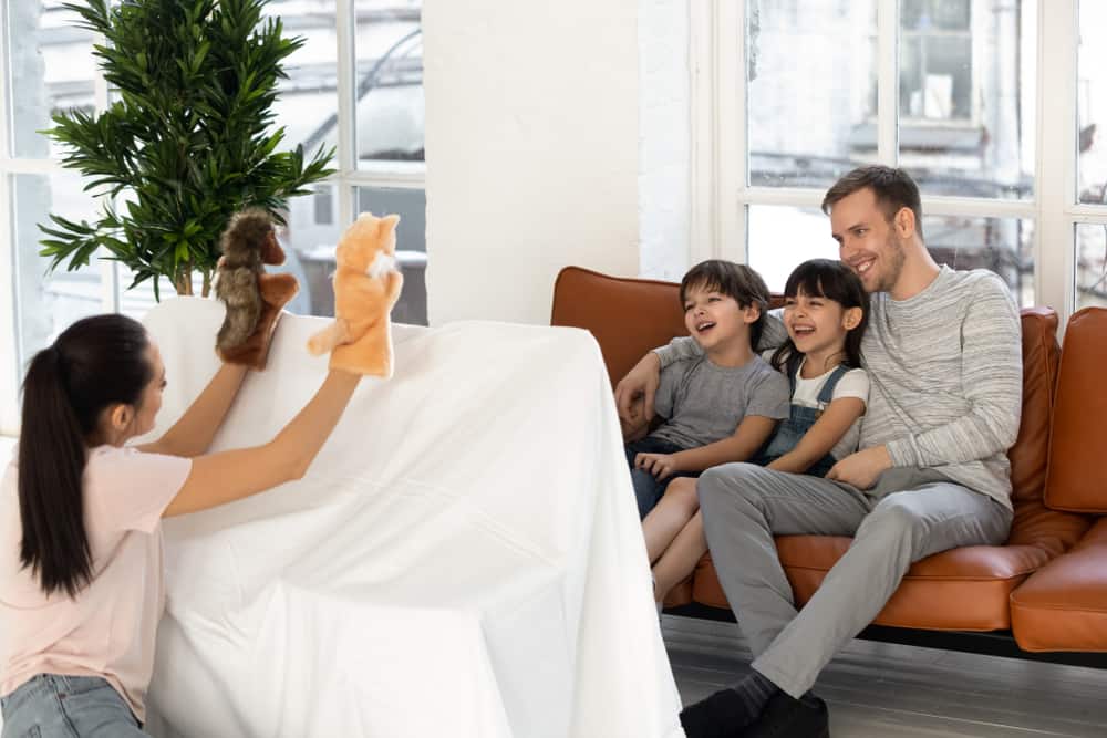 200 Best Indoor Activities for Kids 11 A family doing a puppet show in the living room.