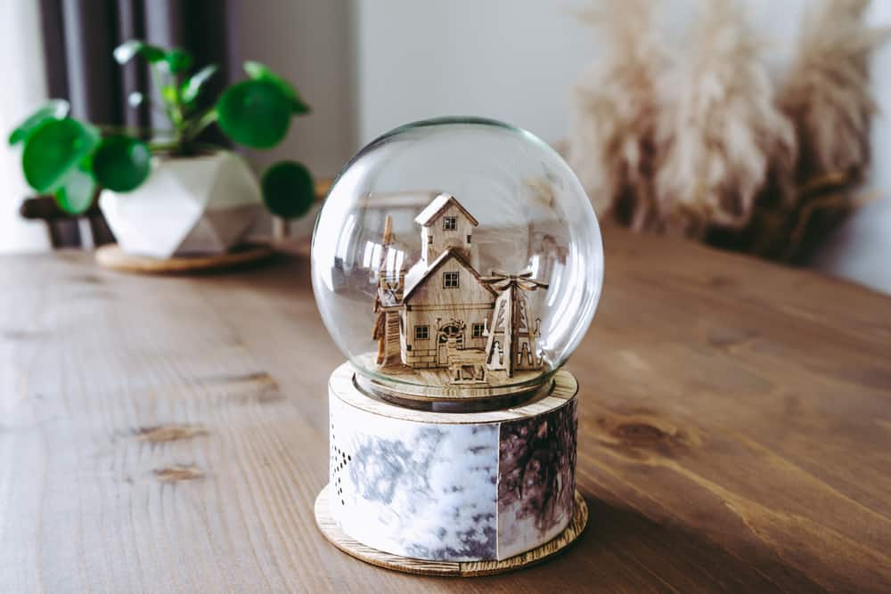 200 Best Indoor Activities for Kids 16 This is a big homemade snowglobe on a wooden table.