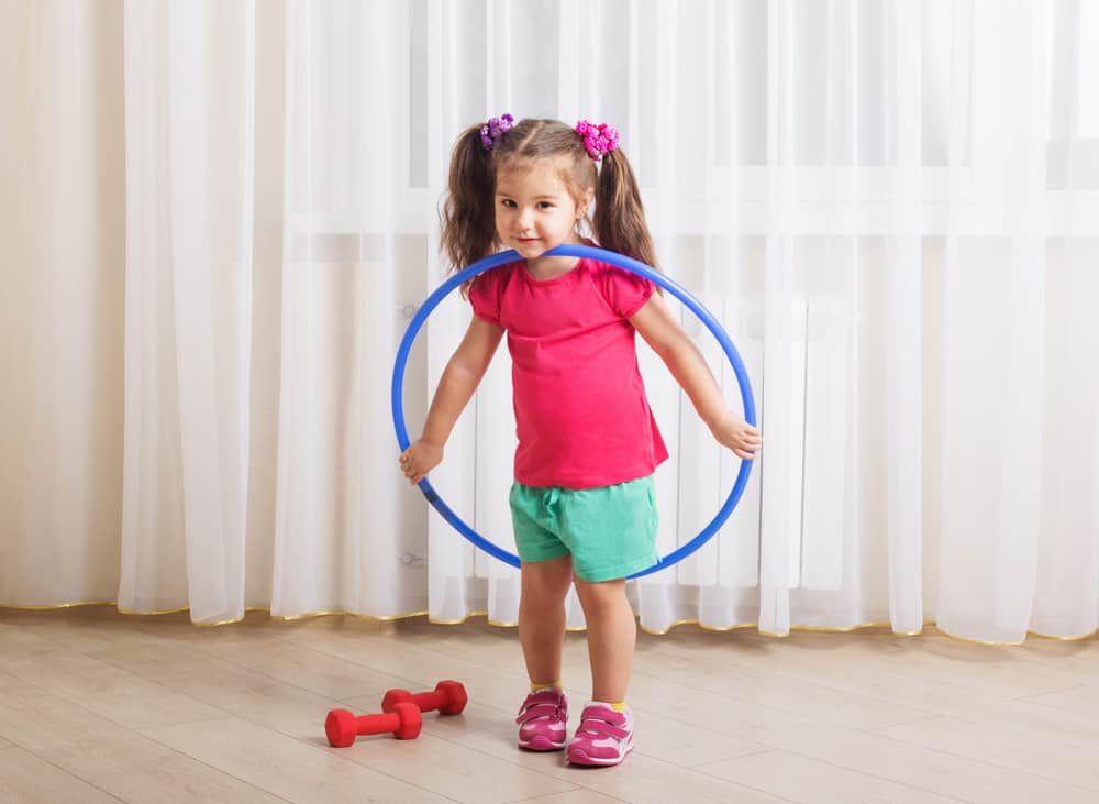 200 Best Indoor Activities for Kids 17 A little girl playing with a hula hoop.