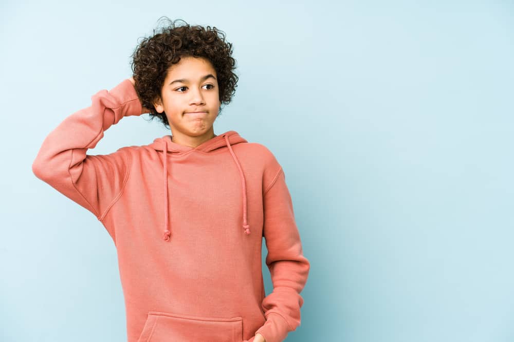 250 Best Would You Rather Questions for Teens 2 A teen boy scratching his head in confusion.