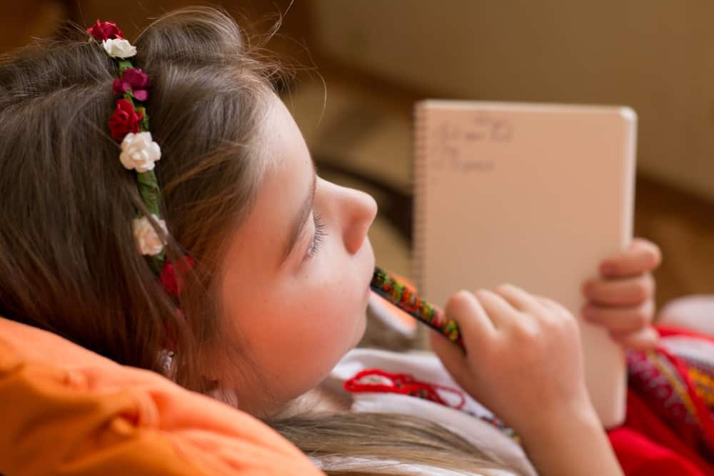 200 Best Indoor Activities for Kids 7 A close look at a girl writing on her journal.