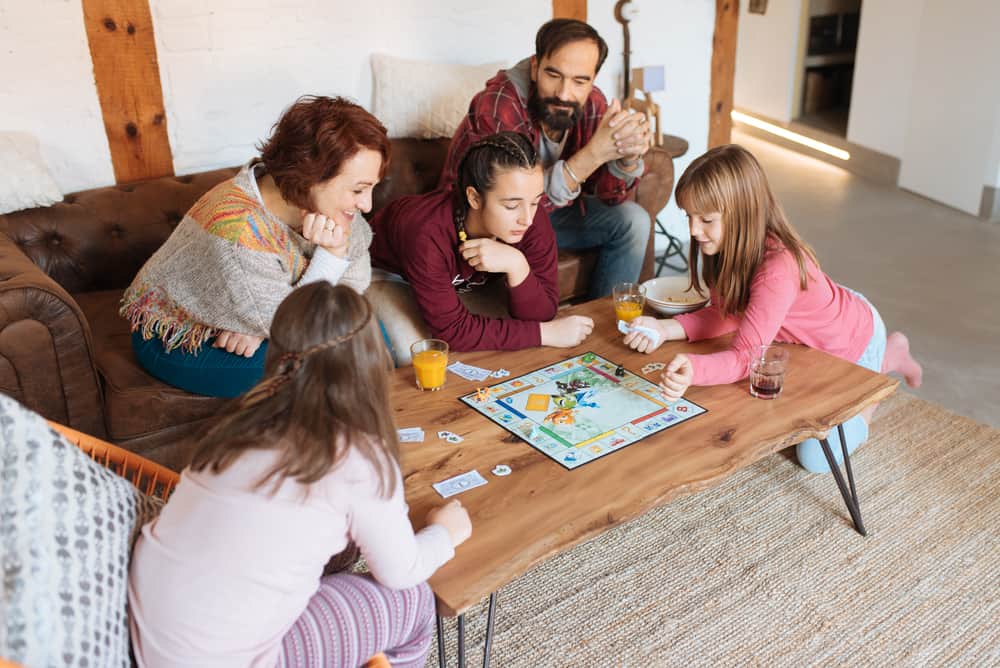 200 Best Indoor Activities for Kids 9 This is a family playing a board game in the living room.