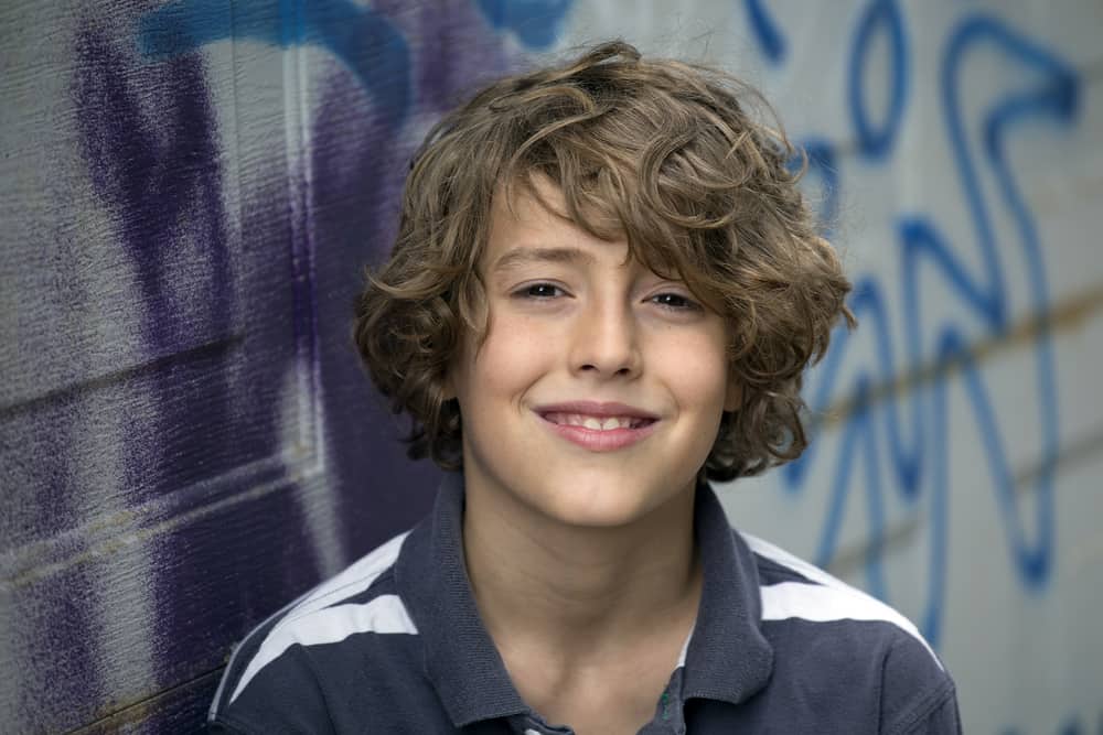 A smiling brown-haired 11-year-old boy wearing a gray shirt.