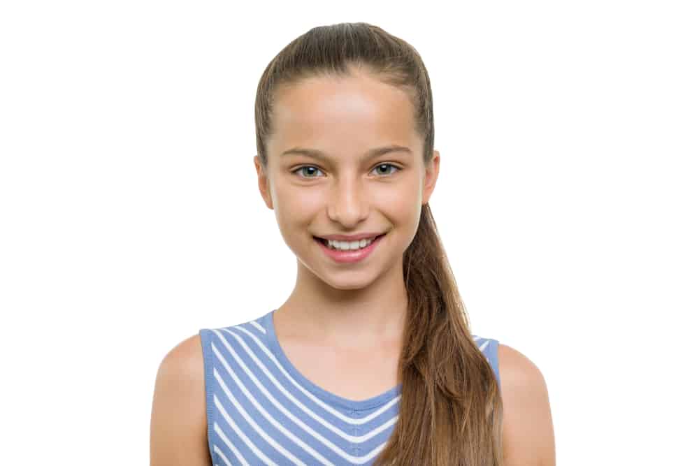 This is a brown haired 11-year-old girl wearing a striped dress.