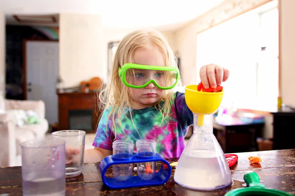 Science activities for kids: Little girl doing a science experiment at home.