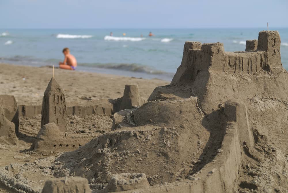 50 Best Group Activities For Kids 3 A close look at a sand castle fort at the beach.