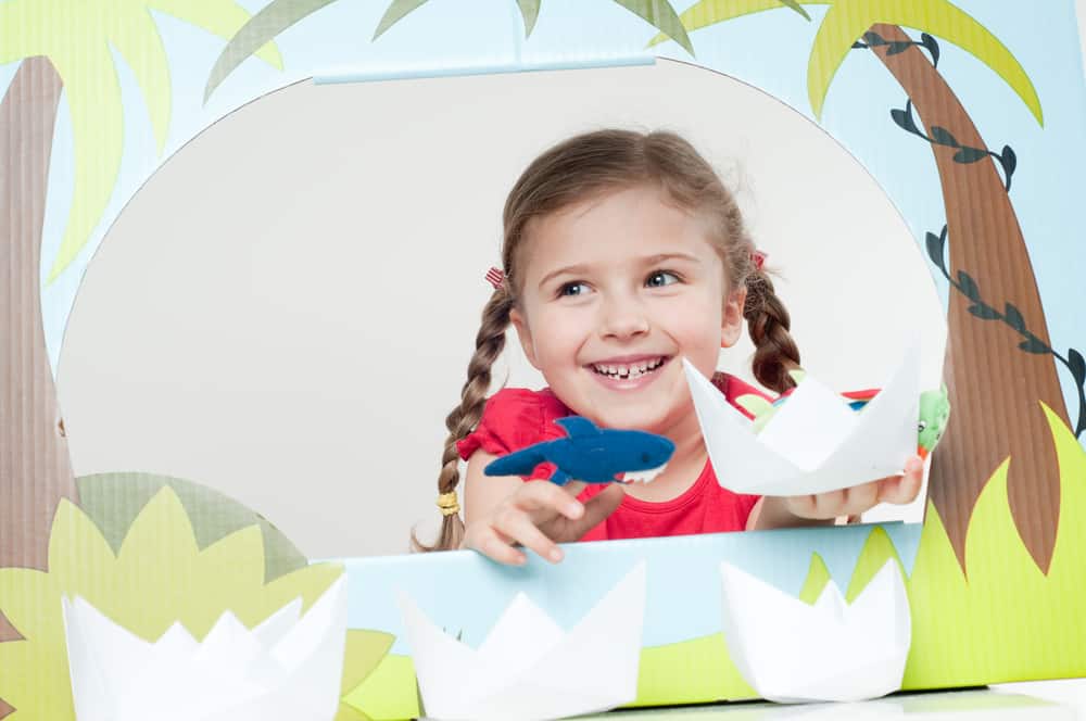 50 Best Group Activities For Kids 8 A girl doing finger puppets with a tropical theme.