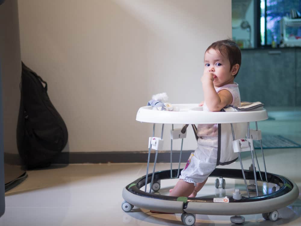 Baby girl in a walker learning to walk.
