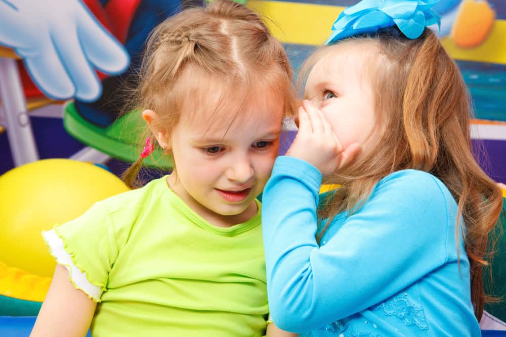50 Best Music Activities for Kids 7 Little girl whispering something to her playmate.