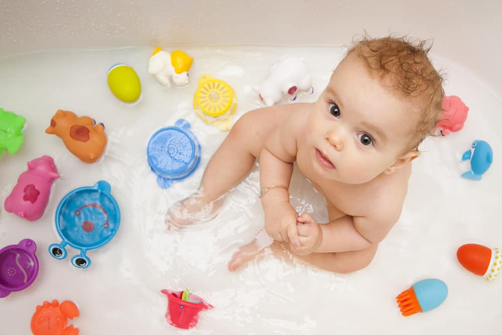Baby in bathtub with color-changing toys. Toys that change color in water.