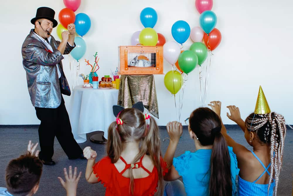 100 Best Kids Birthday Party Ideas 7 A magician performing in front of the kids in a birthday party.