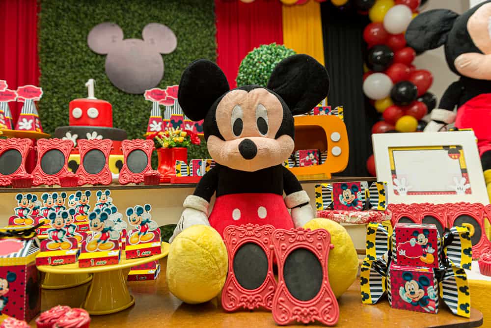 100 Best Kids Birthday Party Ideas 17 Birthday reception with Mickey Mouse theme featuring a large plush toy, candies, and cake.