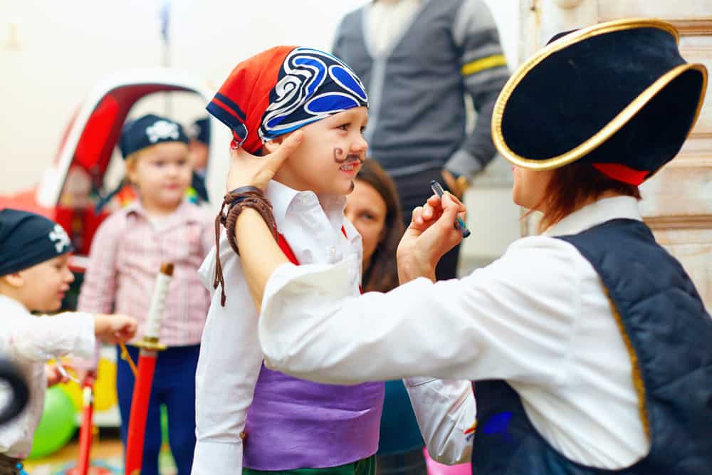 100 Best Kids Birthday Party Ideas 11 Woman painting the face of birthday boy in pirate costume.
