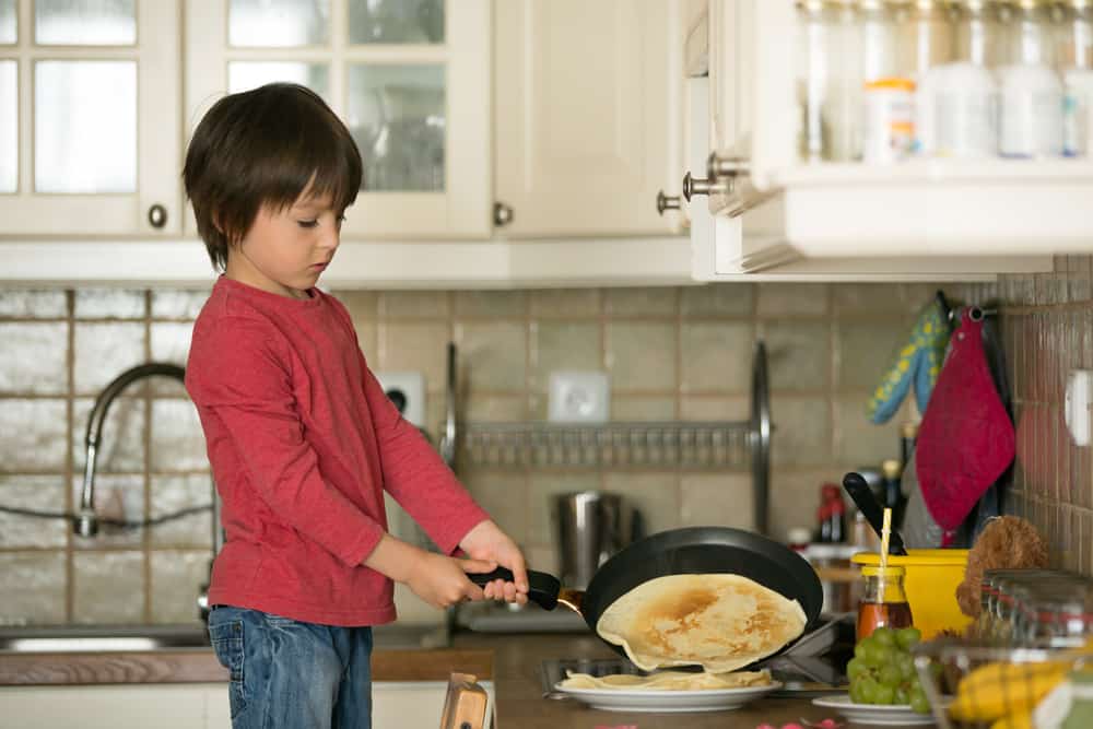 20 Best Chores for 7-9 Year Olds 4 Boy in the kitchen making pancake.