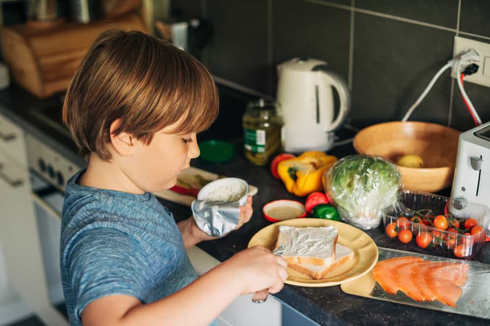 20 Best Chores for 7-9 Year Olds 5 Little boy in the kitchen making sandwich.