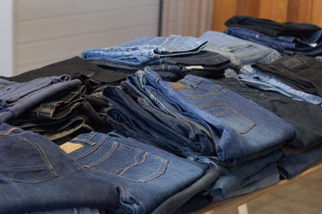 Piles of folded pants in a store.