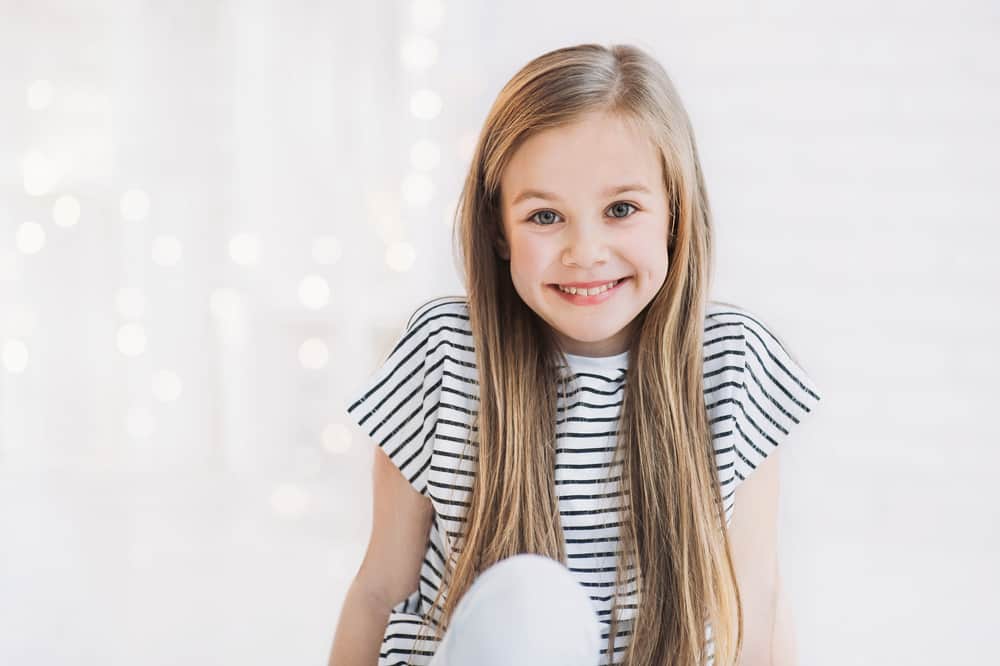 Girl wearing a striped shirt against the bokeh background.