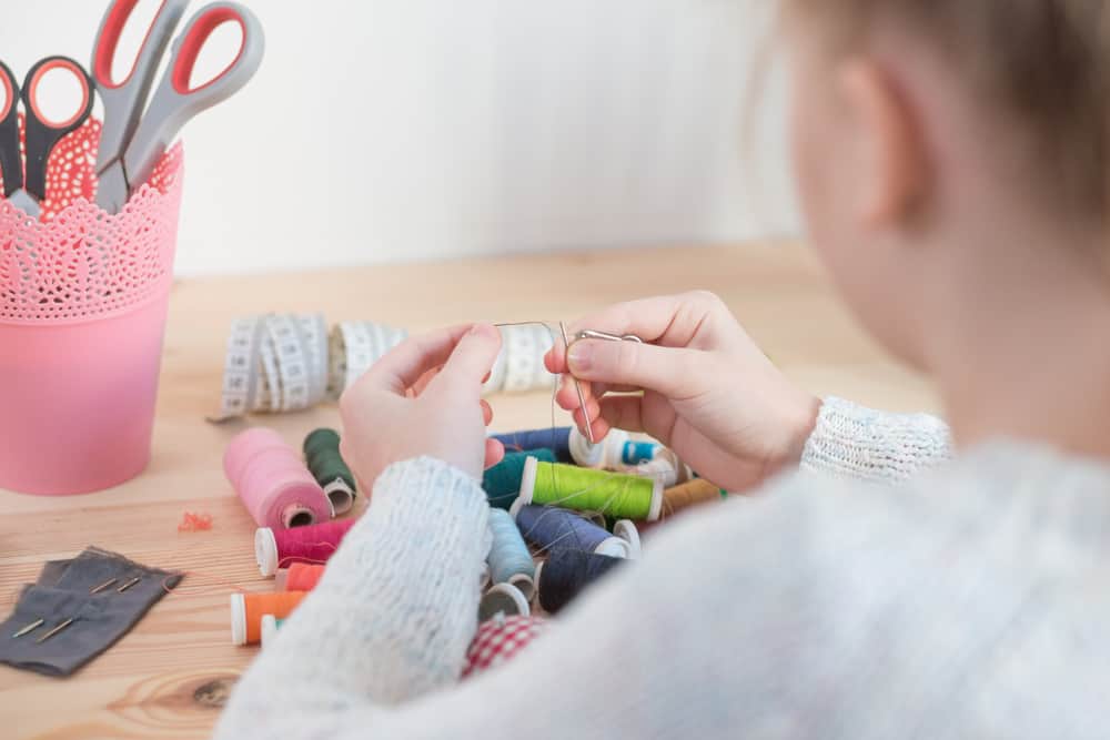 20 Best Chores for 7-9 Year Olds 18 Little girl putting thread into the needle.