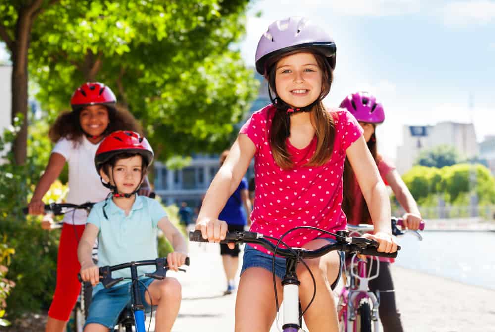 Girl with her friends riding bike on a park.