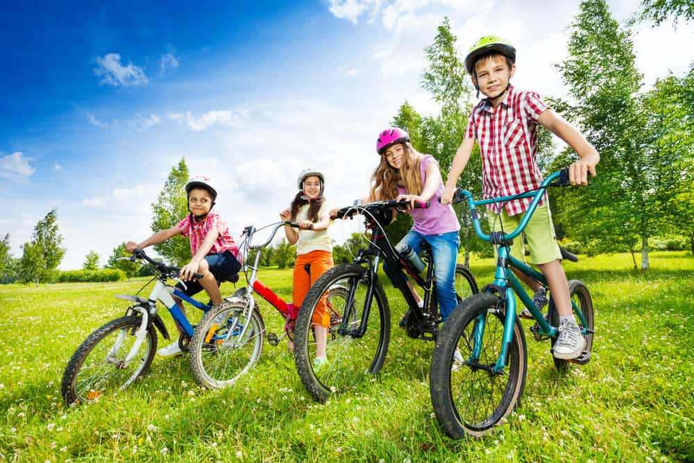 A group of friends riding bike in a field.