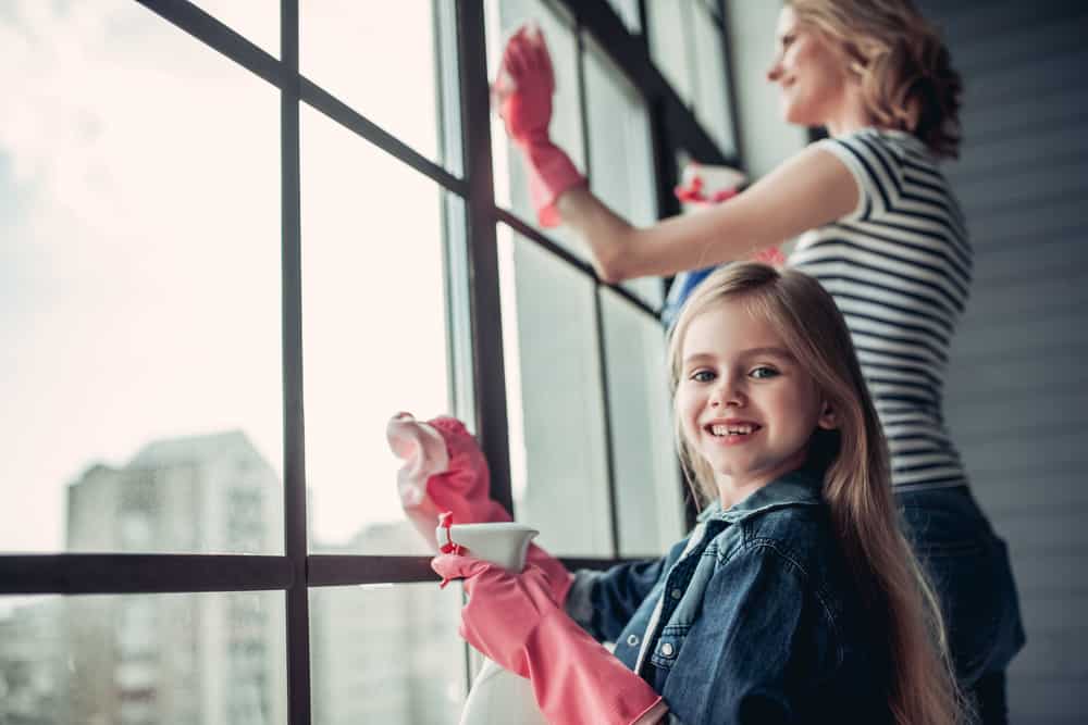 Chores for 7-9 year olds: Mother and daughter cleaning the windows at home.