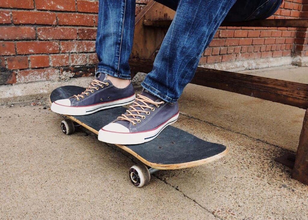 6 Popular Types of Skateboards for Kids 1 kid's feet resting on a skateboard.