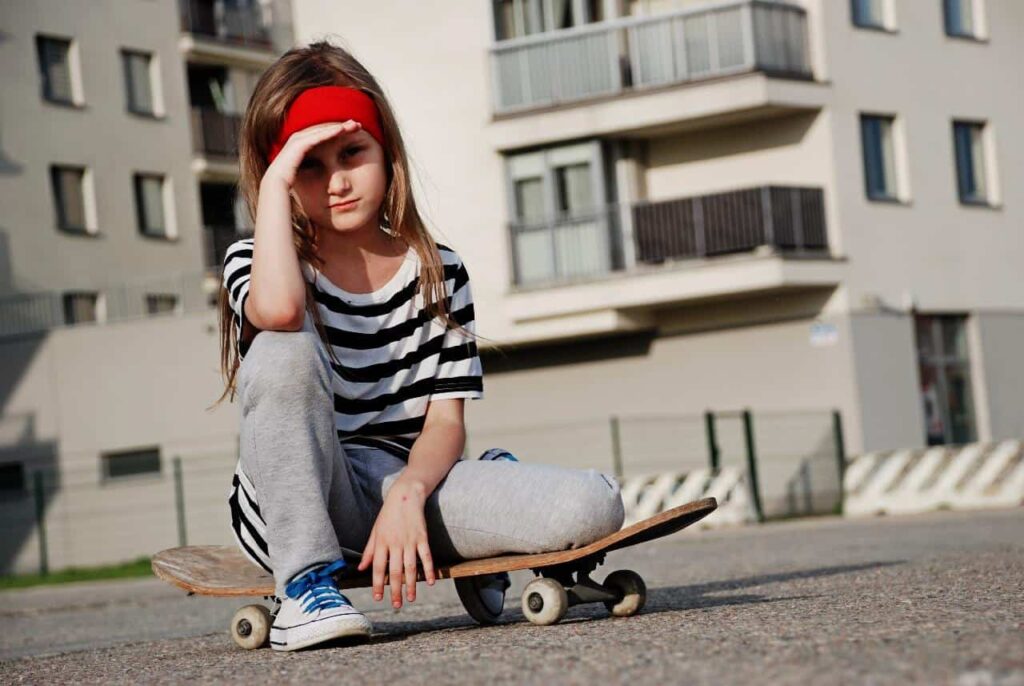Little girl riding a skateboard.
