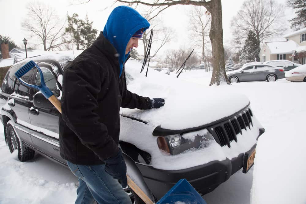 44 Best Chores for Teenagers 18 Teen shoveling off snow from the car.
