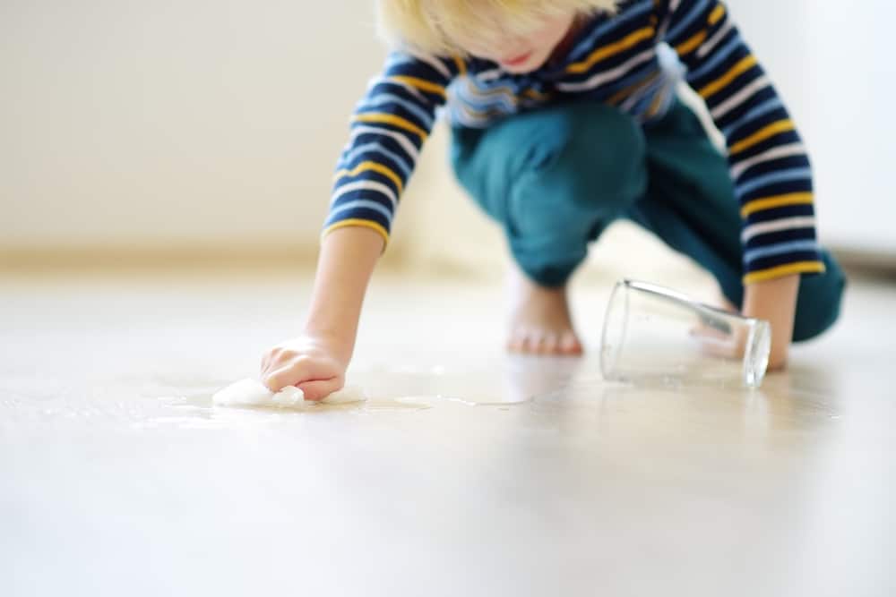 15 Best Chores for 5-6 Year Olds 8 Little boy wiping spilled water on the floor.