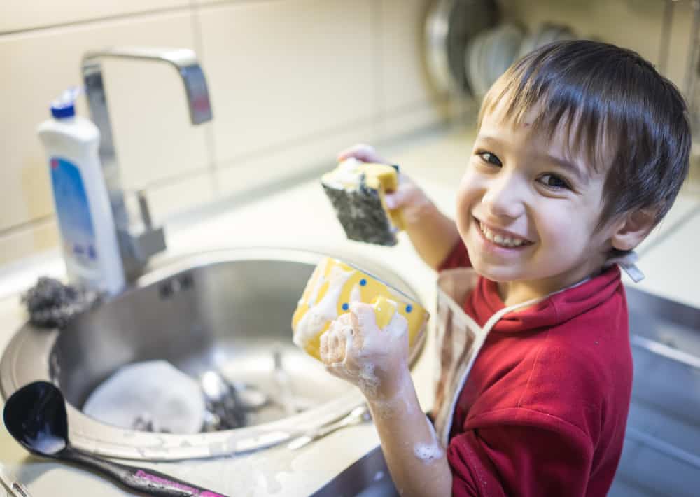 Chores for 5-6 year olds: Little boy washing the dishes.