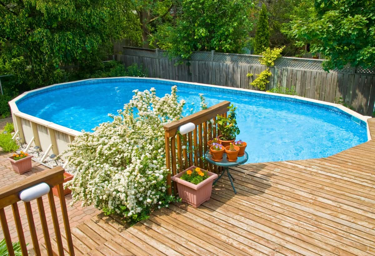 Above ground pool in the backyard with deck.