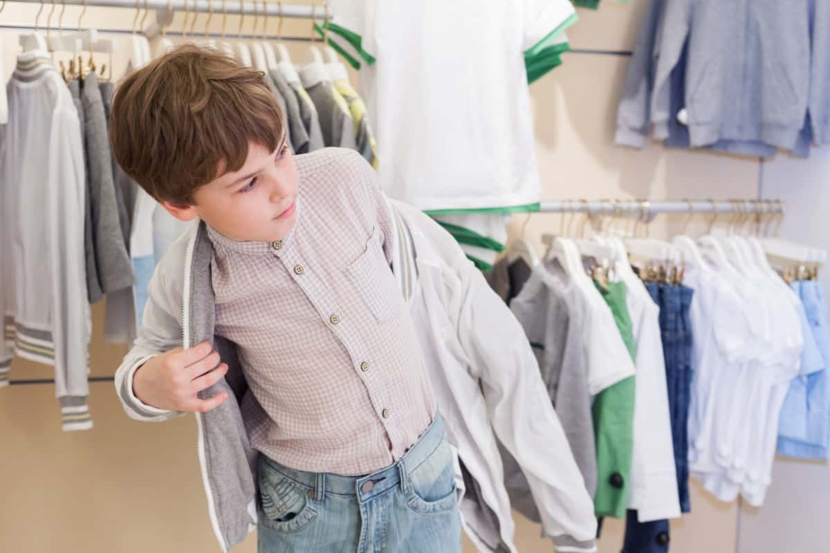 Little boy trying on clothes in a store.