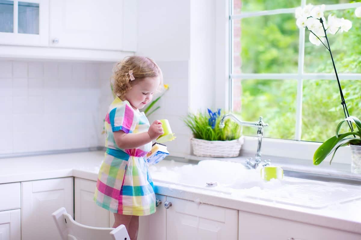20 Best Chores for 3-4 Year Olds 9 Little girl washing plastic dishes.