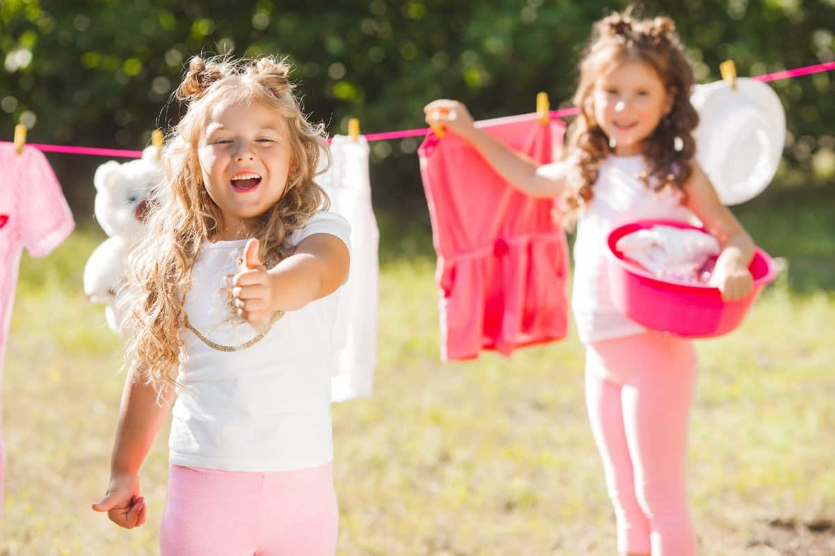 20 Best Chores for 3-4 Year Olds 5 Kids hang laundry on the washing line.