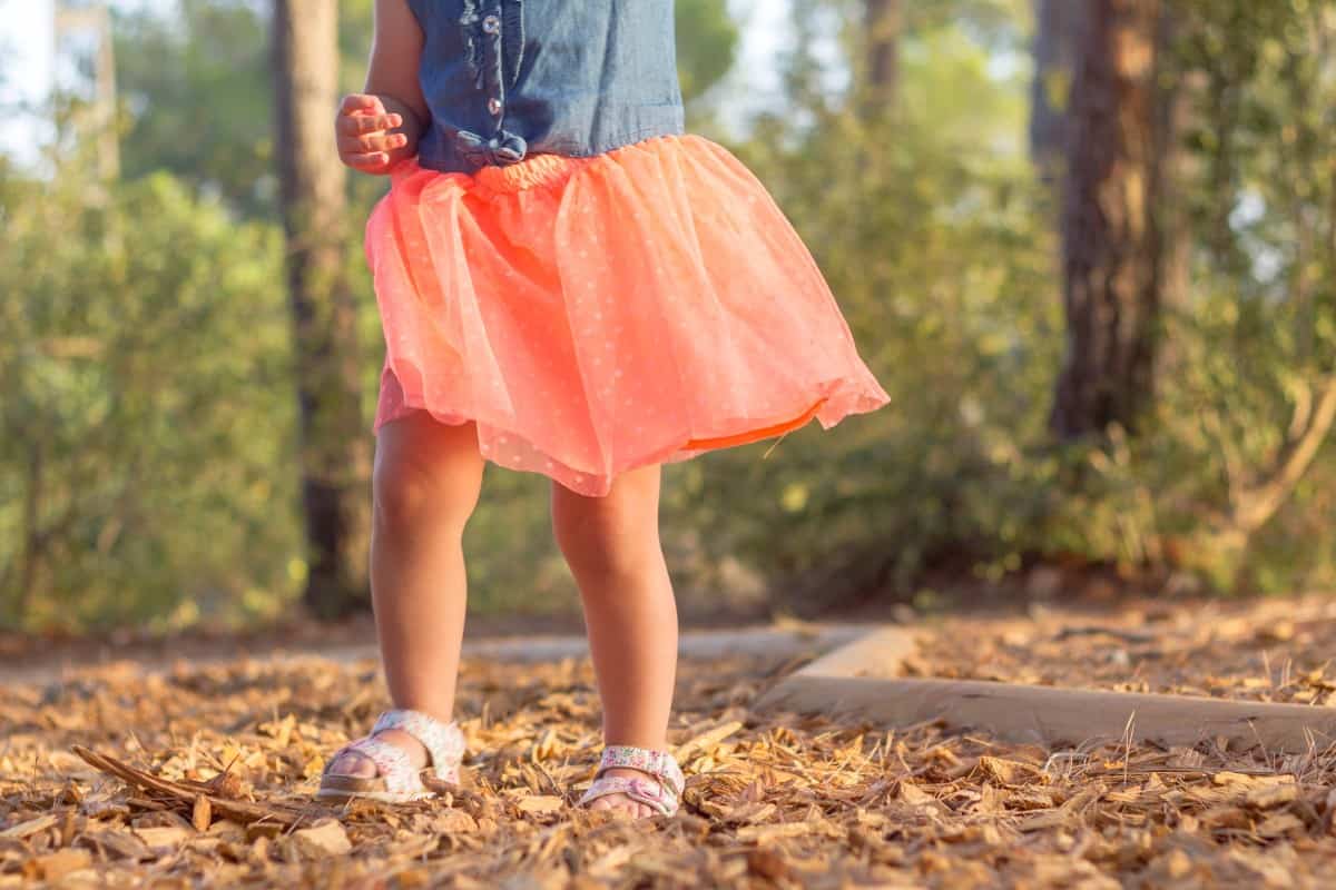 Little girl wearing sandals in the park.