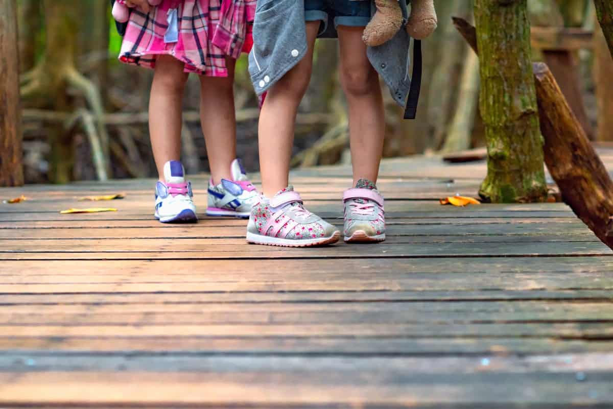 Kids wearing sneakers outdoors.